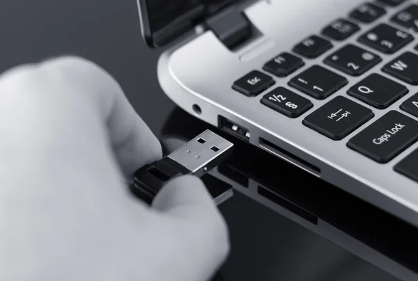 Hand stecken USB-Stick auf Laptop. Schwarz-Weiß-Foto. — Stockfoto