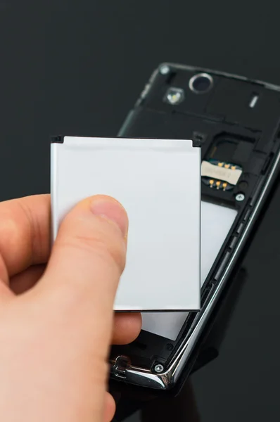 Male hand inserting battery to mobile phone. — Stock Photo, Image