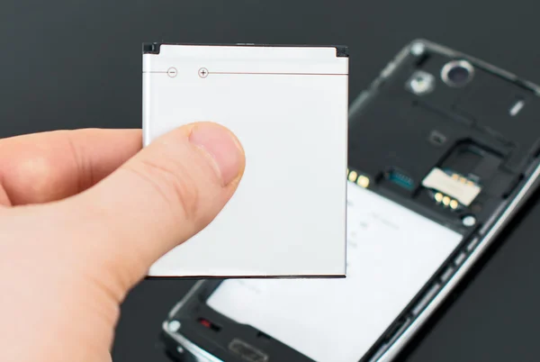 Male hand inserting battery to mobile phone. — Stock Photo, Image