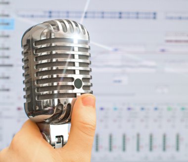 Hand holding retro microphone over recording software background. clipart