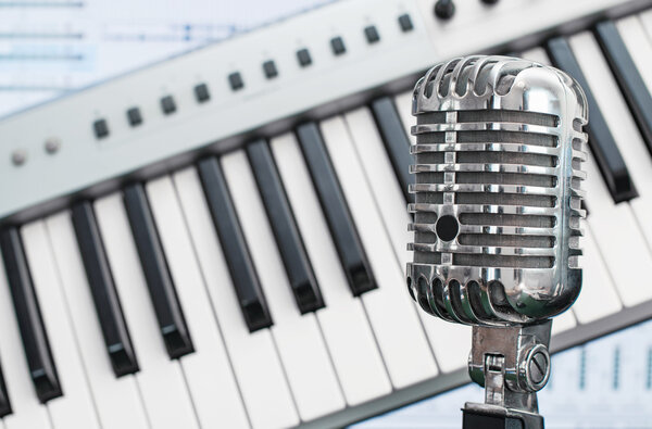 Retro microphone over piano and recording software background.