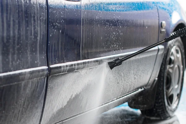 Lavagem de carro azul usando jato de água de alta pressão . — Fotografia de Stock