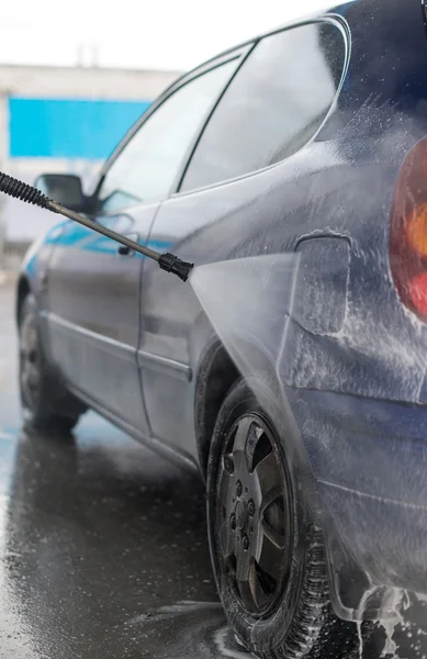 Blauwe auto wassen met behulp van hoge druk waterstraal. — Stockfoto