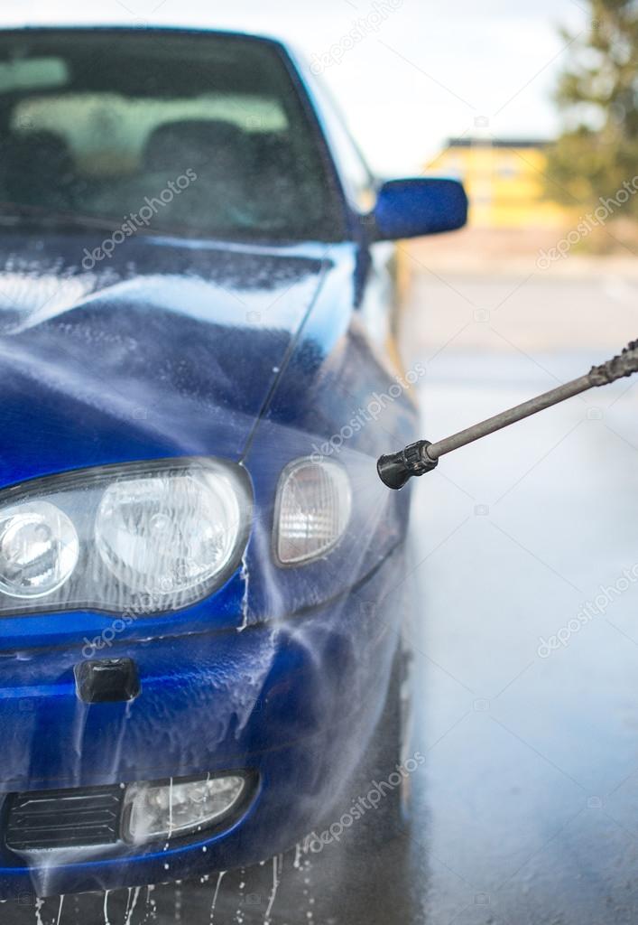 Blue car wash using high pressure water jet.