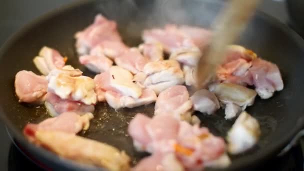 Человек готовит курицу на сковороде . — стоковое видео