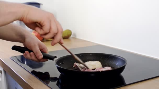 Homme cuisine poulet sur poêle .