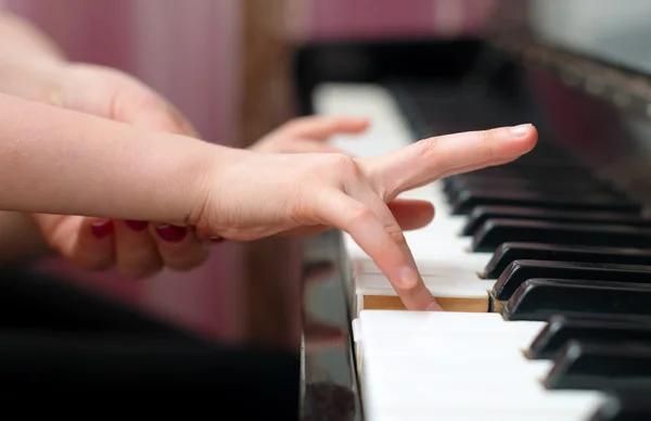 Mulher ensina a criança a tocar piano . — Fotografia de Stock