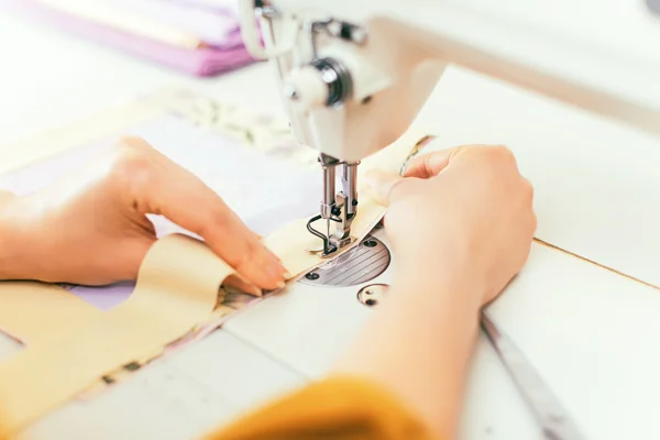 Les mains de la femme travaillant sur la machine à coudre . — Photo