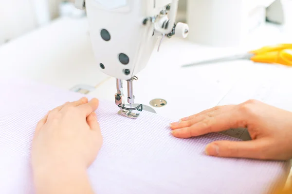 Las manos de la mujer trabajando en la máquina de coser . — Foto de Stock