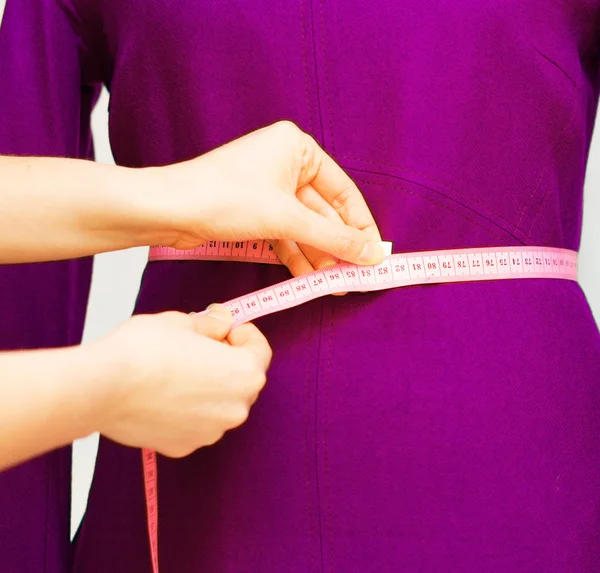 Fashion designer with measuring tape working on mannequin. — Stock Photo, Image