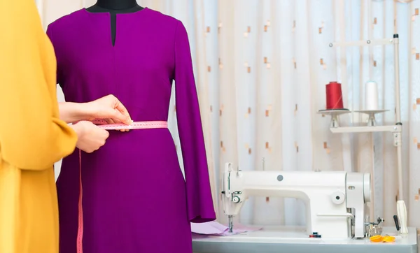 Fashion designer with measuring tape working on mannequin. — Stock Photo, Image