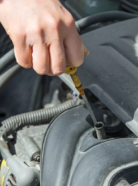 Vrouw controleren oliepeil in auto. — Stockfoto