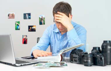 Onun işyerinde çalışan yorgun fotoğrafçı.