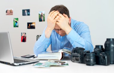 Onun işyerinde çalışan yorgun fotoğrafçı.