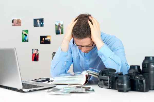 Fotógrafo cansado trabalhando em seu local de trabalho . — Fotografia de Stock