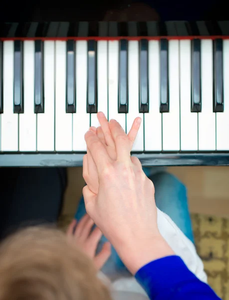 Una donna che insegna alla ragazzina a suonare il pianoforte. Vista dall'alto . — Foto Stock