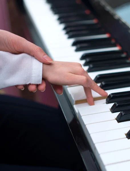 Donna che insegna alla bambina a suonare il pianoforte . — Foto Stock