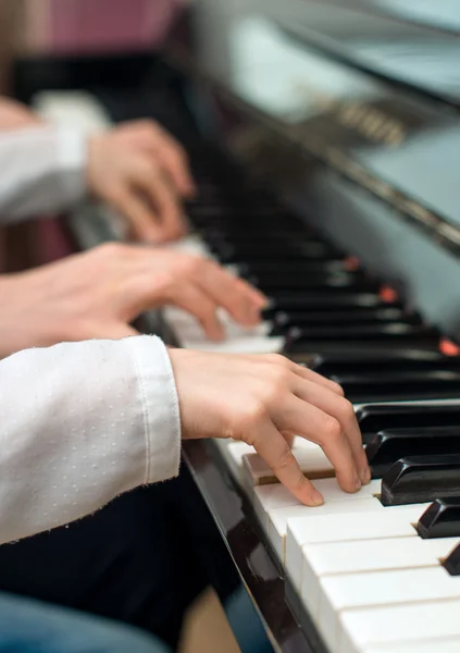 Mulher ensinando menina a tocar piano . — Fotografia de Stock