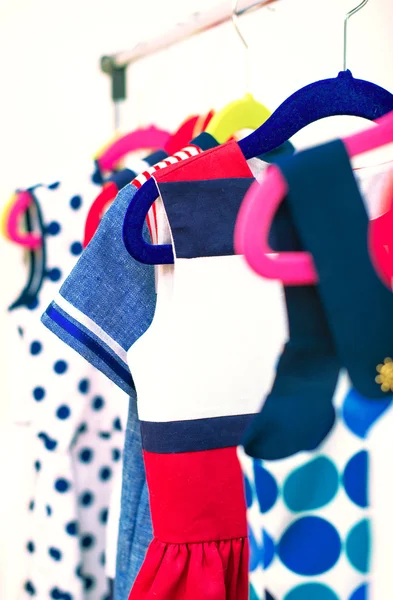 Allerlei kleurrijke jurken op hangers in winkel. — Stockfoto