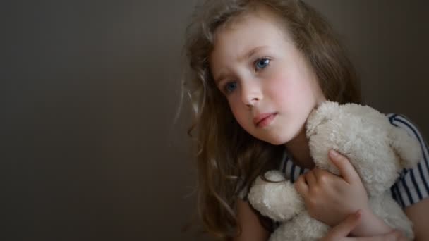 Triest meisje met beer in de buurt van de muur. — Stockvideo