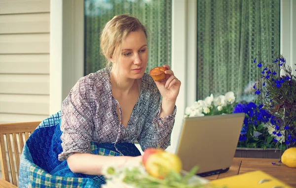 Frau mit Laptop im Garten im Urlaub. — Stockfoto