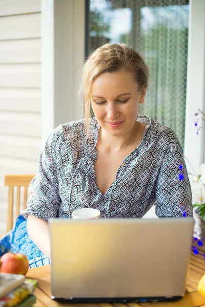 Frau mit Laptop im Garten im Urlaub. — Stockfoto