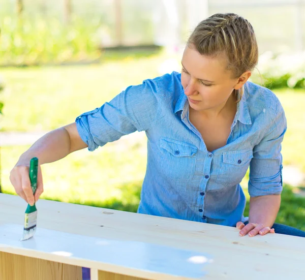 Nő kefével festés fa bútorok. — Stock Fotó