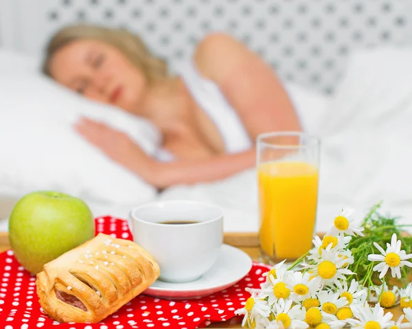 Breakfast in bed. Sleeping woman on background. — Stock Photo, Image