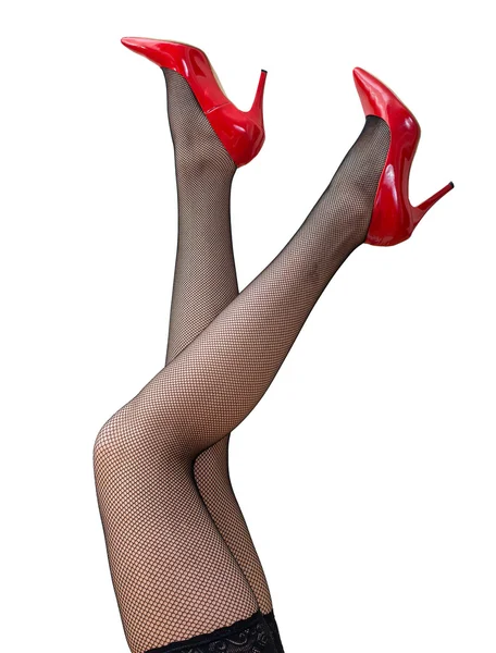 Jambes féminines sexy en collants noirs et chaussures rouges soulevées . — Photo