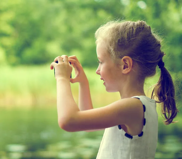 Weinig meisje het maken van video of foto met mobiele telefoon. — Stockfoto