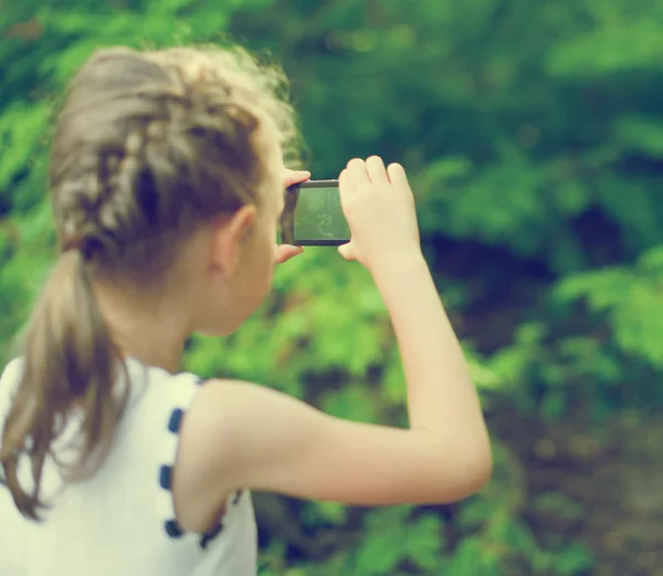 Девочка снимает видео или фото с мобильного телефона . — стоковое фото