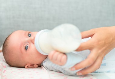 Anne yeni doğmuş bebeği şişeden besliyor..