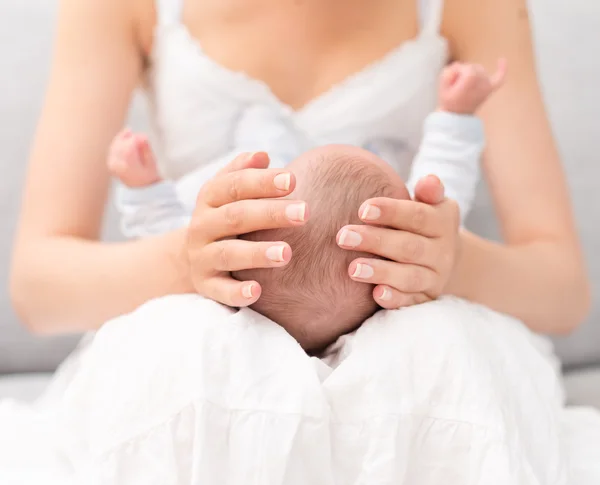 Mãe está segurando bebê recém-nascido de joelhos . — Fotografia de Stock