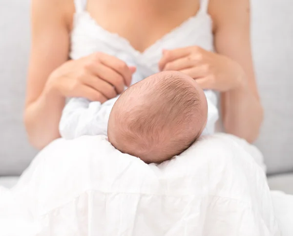 Mother is holding newborn baby on her knees. — Stock Photo, Image