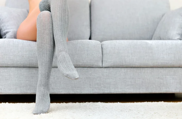 Жінка з красивими ногами сидить на дивані . — стокове фото