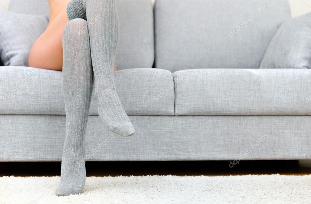 Woman with beautiful legs sitting on sofa.