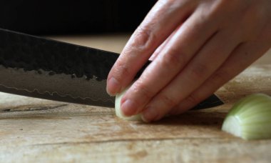 Kadın Aşçı Tahta Kesme Kurulunda Soğan Kesiyor.