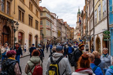 Prag, Çek Cumhuriyeti - 08.05.2025: St. Nicholas Kilisesi ile kalabalık kaldırım taşı caddesi Lazenska.