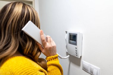 Bir kadın ev telefonundan konuşuyor..