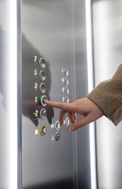 Kadın acil düğme Asansör içinde.
