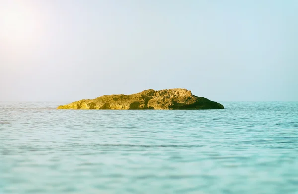 Isola solitaria in un mare blu profondo . — Foto Stock