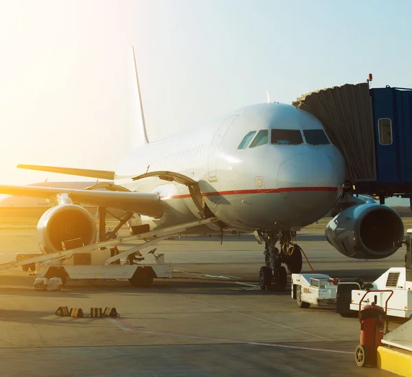 Passenger plane in the airport at sunrise. Aircraft maintenance. — Stock Photo, Image