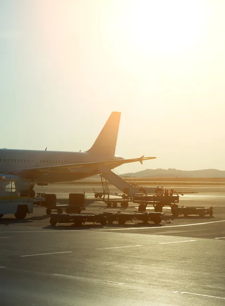 Avión de pasajeros en el aeropuerto al amanecer. Mantenimiento de aeronaves . — Foto de Stock