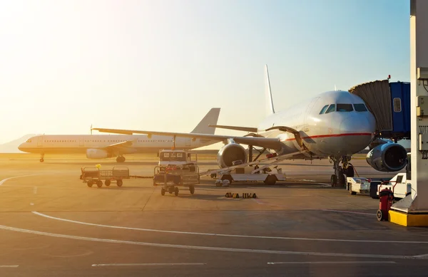 Passenger plane in the airport at sunrise. Aircraft maintenance. — Stock Photo, Image