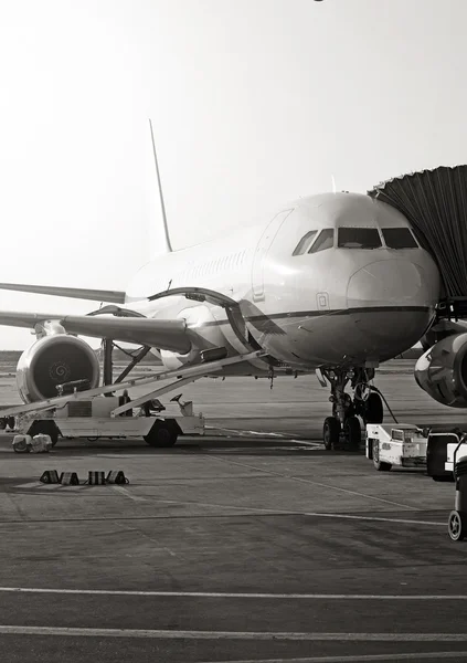 Avion passager à l'aéroport. Entretien des aéronefs. Photo noir et blanc . — Photo