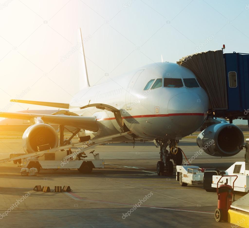 Passenger plane in the airport at sunrise. Aircraft maintenance.