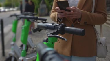 Kadın turist telefonla elektrikli scooter kiraladı.