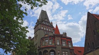 Yüksek çatısı olan neo-gotik bir bina..