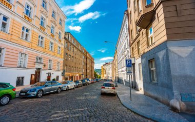 Prag, Çek Cumhuriyeti - 10.05.2025: Otomobillerle parke taşı sokak manzarası.