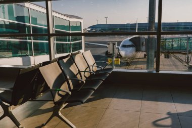 Havaalanı kapısında çekici ve yolcu köprüsü olan yolcu uçağı..